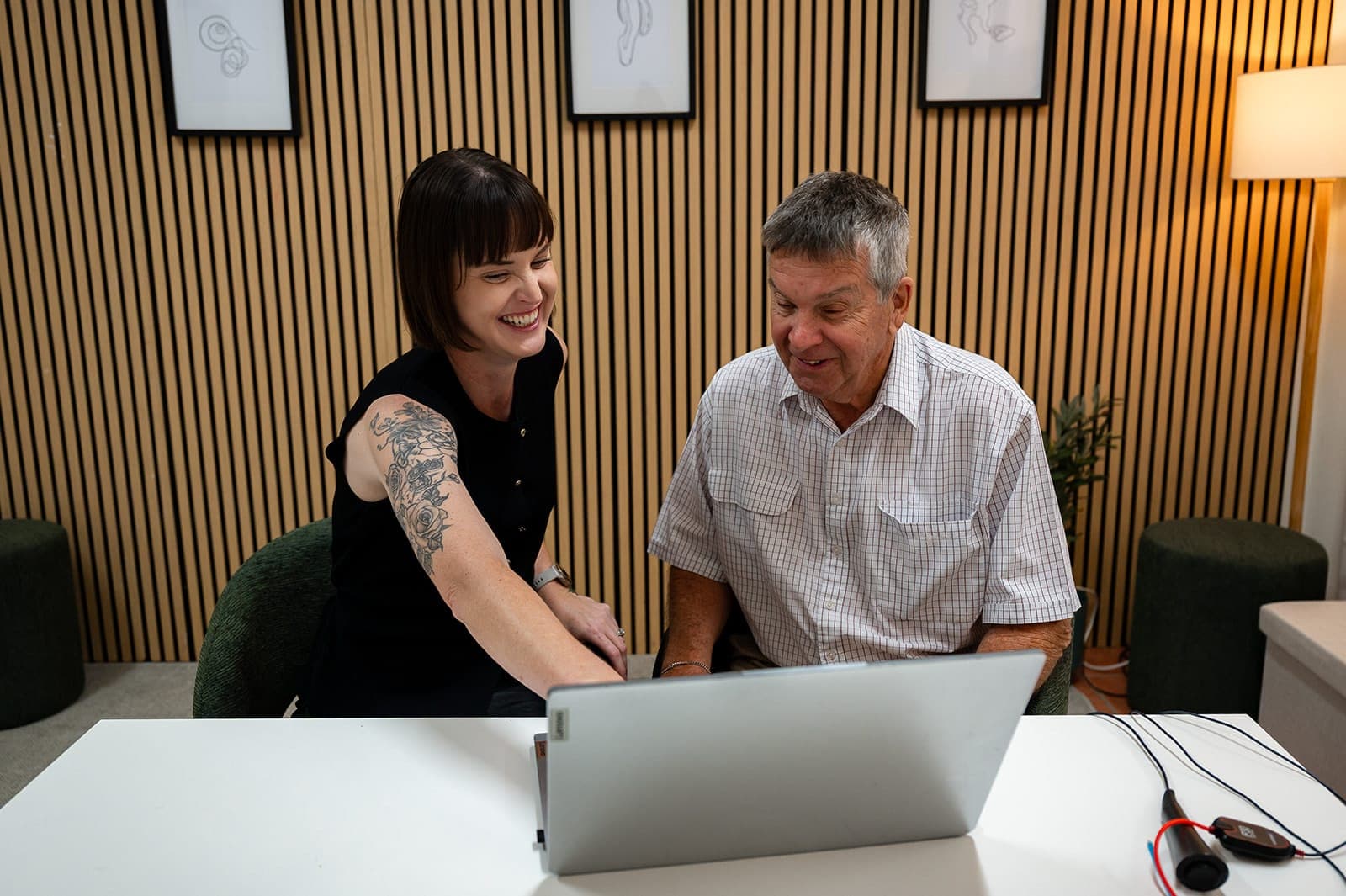 Dr Alison Collins and an older patient laughing together while looking at a laptop